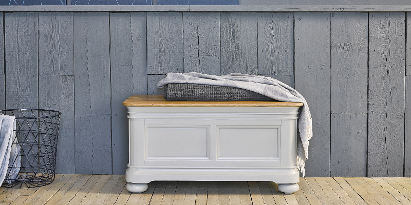 sage green painted blanket box against rustic blue wall