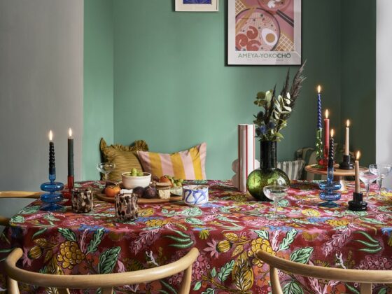 A dining table with chairs-dining room furniture-patterned table cloth-wooden wishbone chairs-statement lighting-green alcove