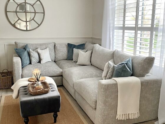 Oak Furnitureland Malvern grey fabric corner sofa with blue and cream scatter cushions.
