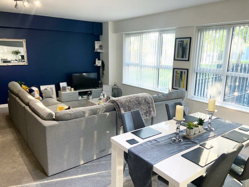 Living and dining space with table and grey sofa