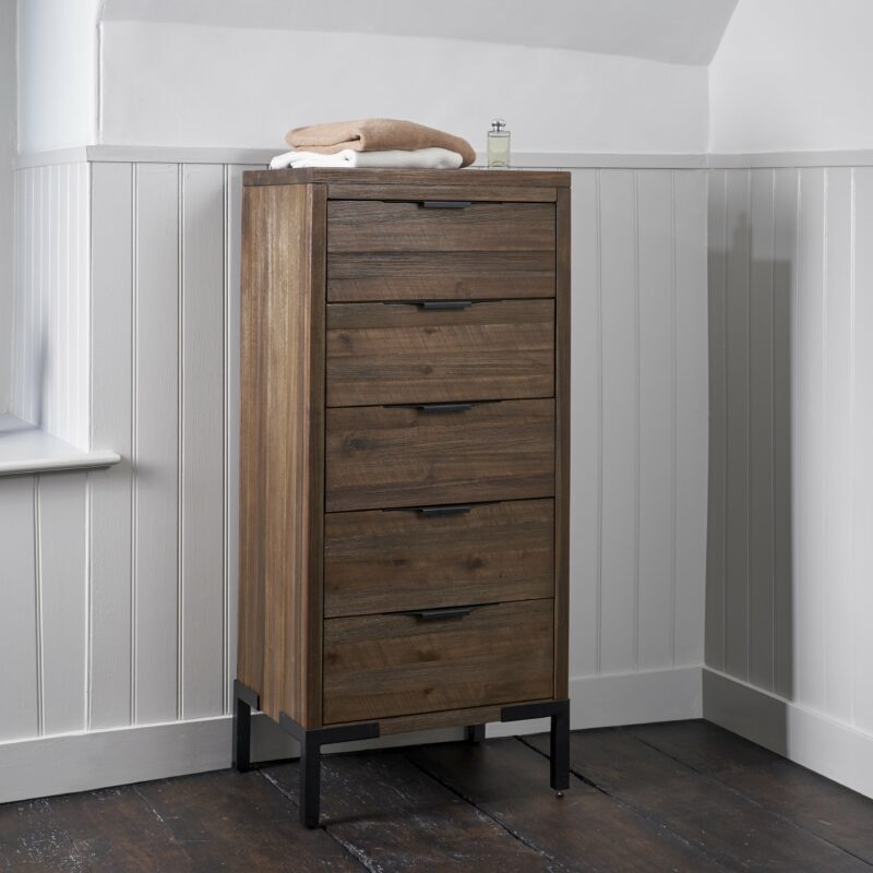 A tallboy-bedroom furniture-dark wood tallboy-half panelled walls-dark wood floor-neutral walls-stacked towels-perfume-metal legs