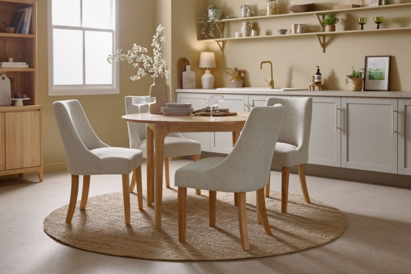 A dining table and chairs-kitchen dining room furniture-oak dining table set-round dining table-cream fabric dining chairs-round jute rug-grey kitchen units-open kitchen shelving-oak dresser