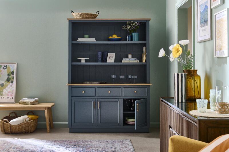 A dresser, bench, and sideboard-dining room furniture-vintage patterned rug-pale oak bench-mustard armchair-large blue dresser-dark wood fluted sideboard-gallery wall