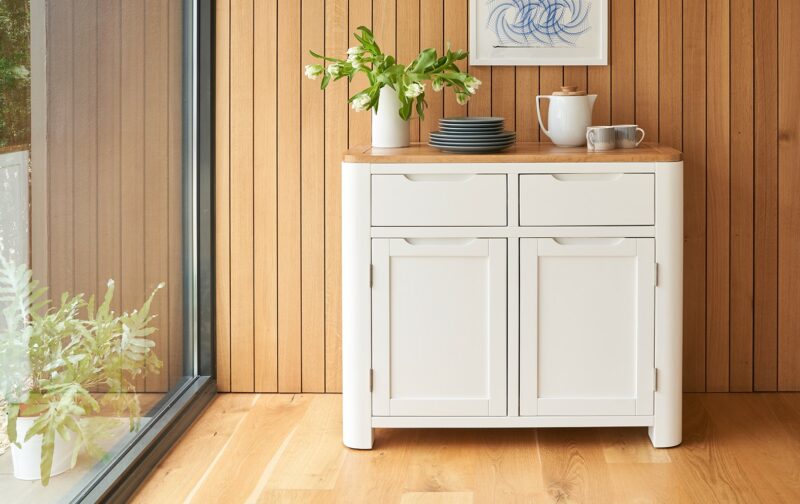 A sideboard-kitchen furniture-small painted wooden sideboard with flowers and crockery on top