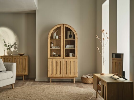 A sofa, TV unit, and cabinet-living room furniture-textured neutral rug-arched wooden display cabinet-pale wooden TV unit-cream sofa-neutral walls