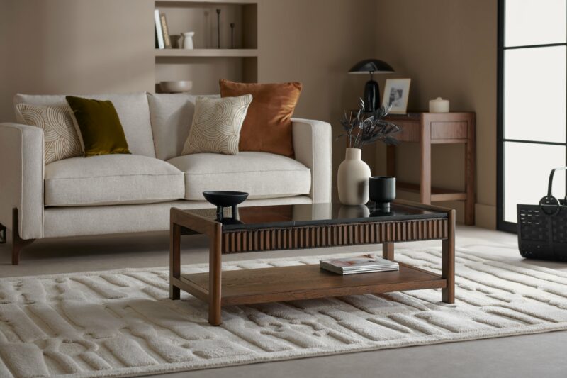 A coffee table and sofa-living room furniture-dark wooden coffee table with black marble top-fluted design-dark wood-cream upholstered sofa-wooden console table