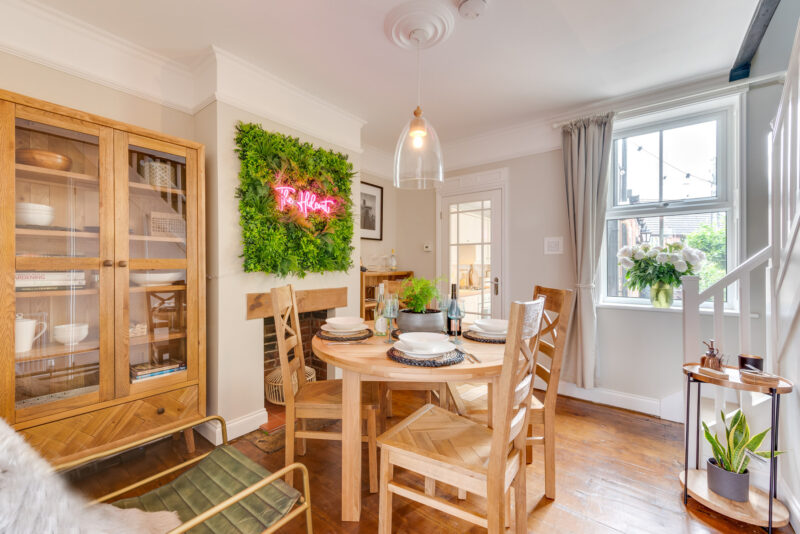Oak Furnitureland Knightsbridge dining table and Parquet display cabinet in dining room with neon sign.
