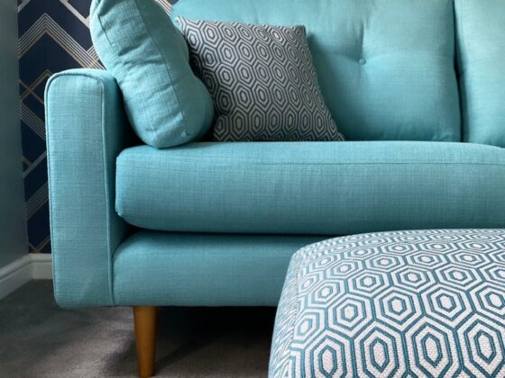 Oak Furnitureland aqua blue Brighton retro-style sofa with geometric patterned footstool and matching scatter cushion.