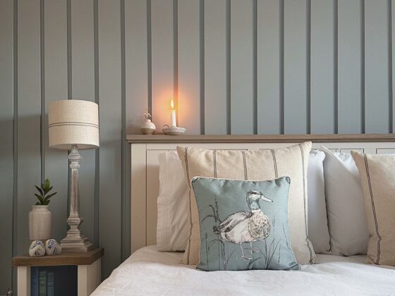 Coastal-inspired bedroom with duck egg blue wall panelling in a peaceful scheme.