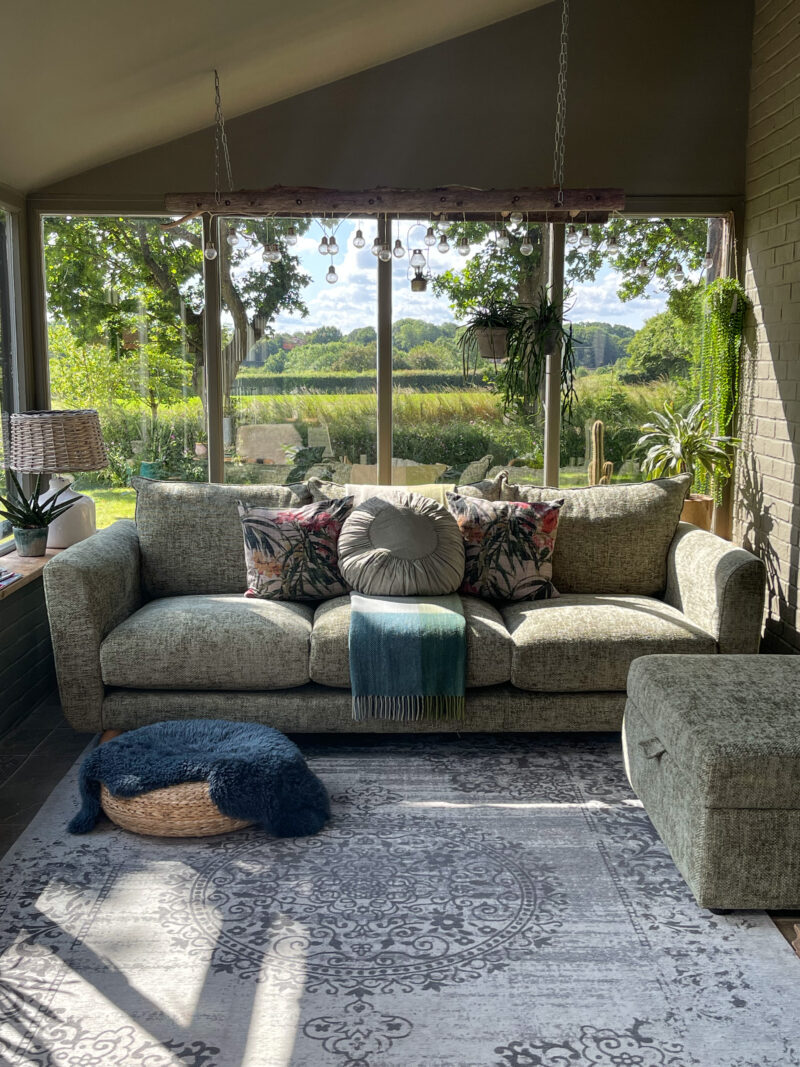 Oak Furnitureland light green sofa and matching storage footstool in a light-filled garden room.