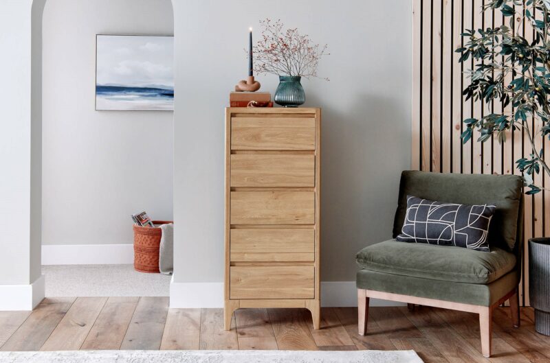 A tallboy and chair-bedroom furniture-wooden five drawer tallboy with green velvet accent chair