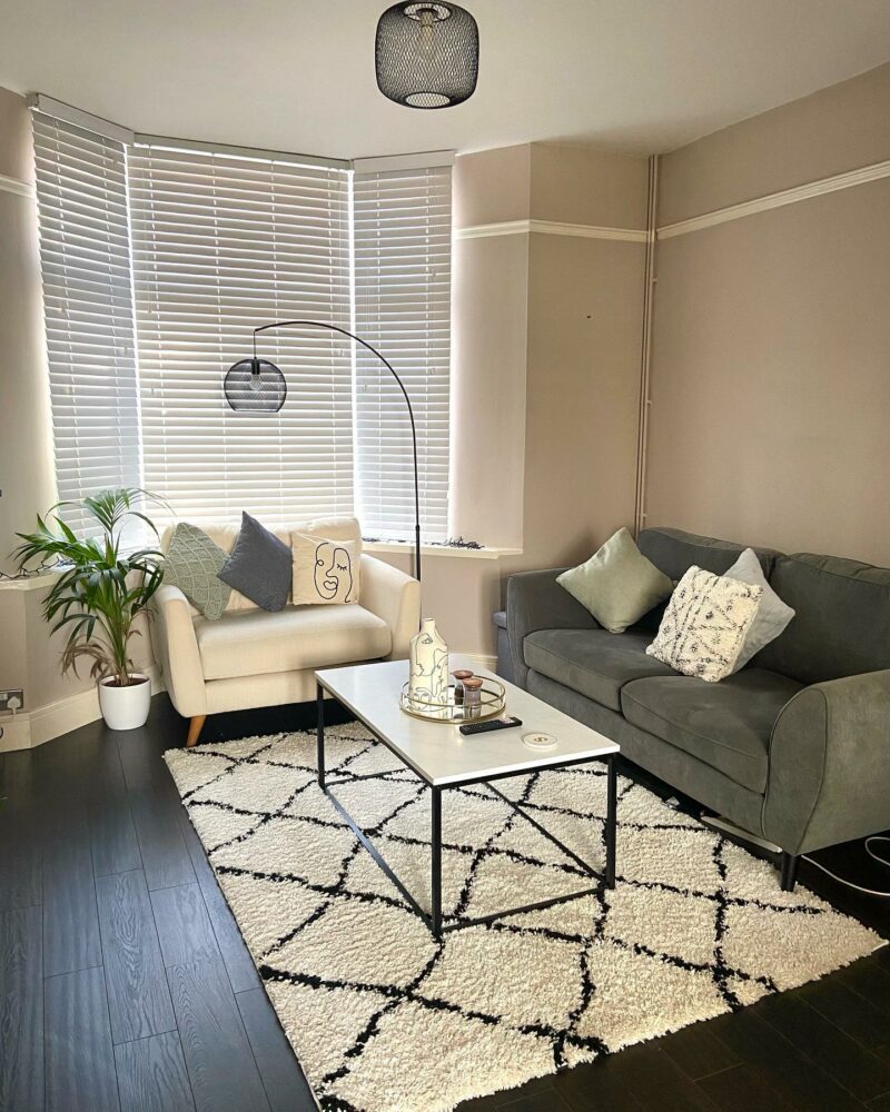 Oak Furnitureland cream Evie loveseat in a living room with neutral decor and a green sofa.