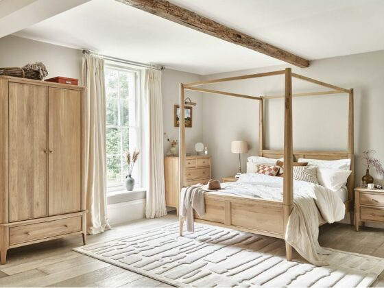 Elegant four-poster natural oak Newton bedroom in a neutral bedroom featuring the whole collection, including wardrobe and chest of drawers, with neutral accents.