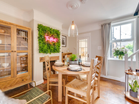 Oak Furnitureland Knightsbridge dining table and Parquet display cabinet in bright room with neon sign