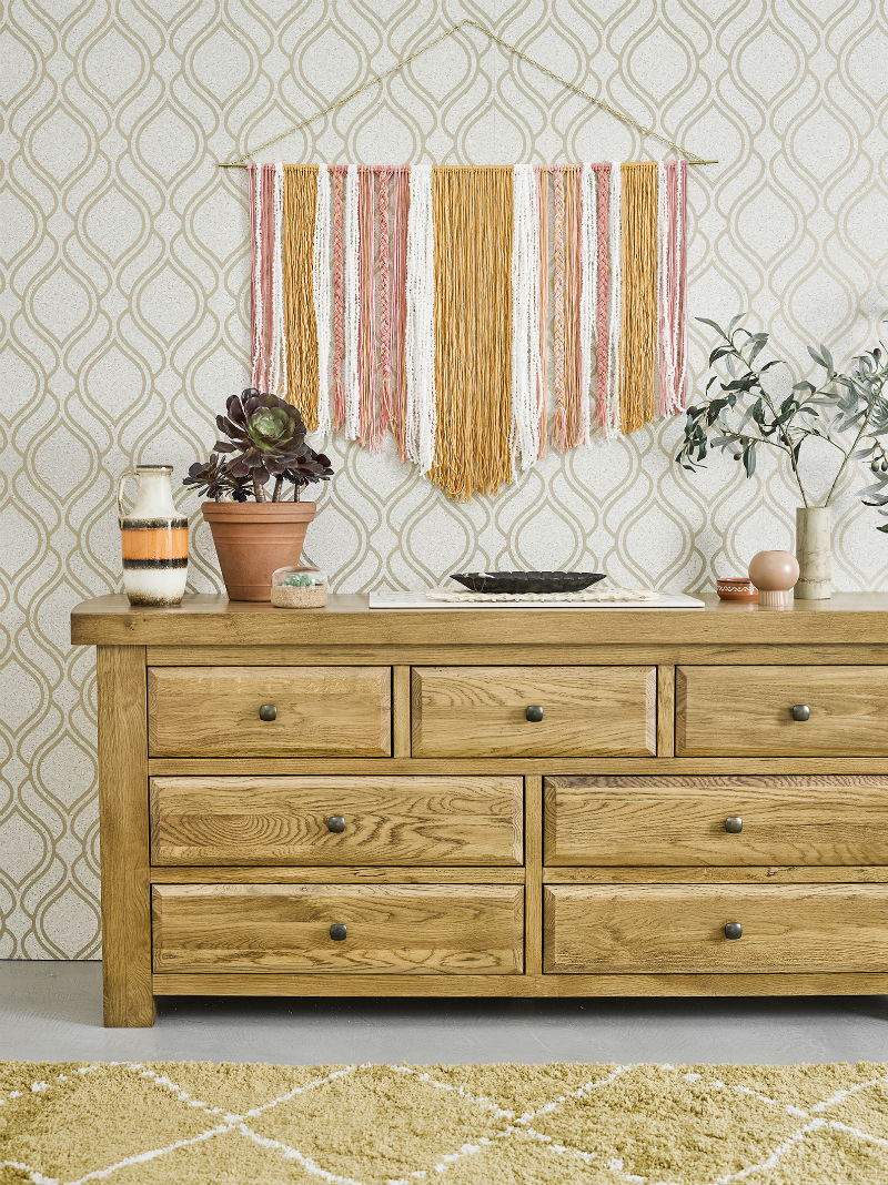 light oak chest of drawers against geometric wallpaper