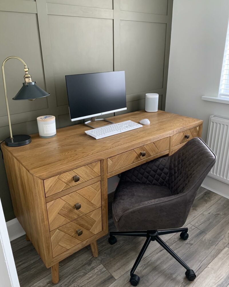 Parquet desk in home office with green wall