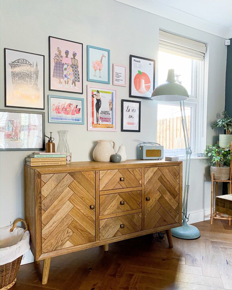 Oak Furnitureland Parquet sideboard topped with decorative accessories and a gallery wall above.