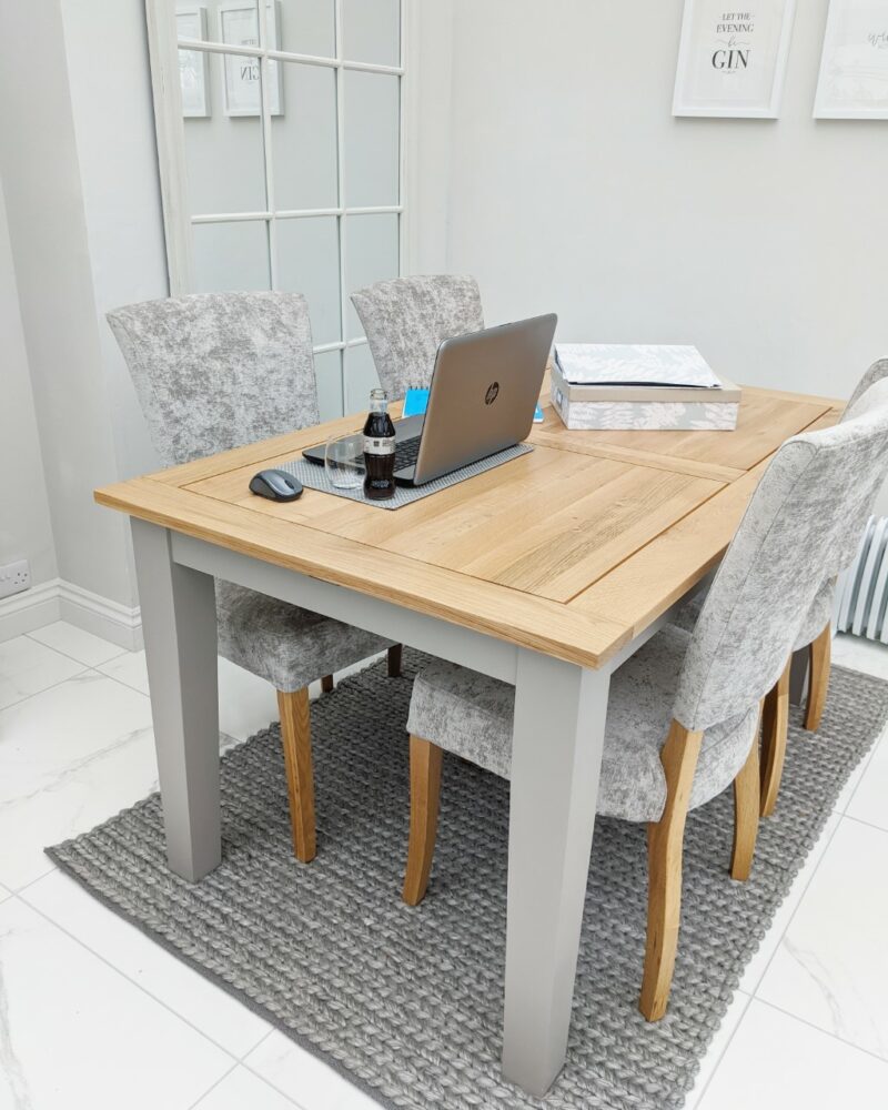 Home working from wooden dining table with grey fabric chairs